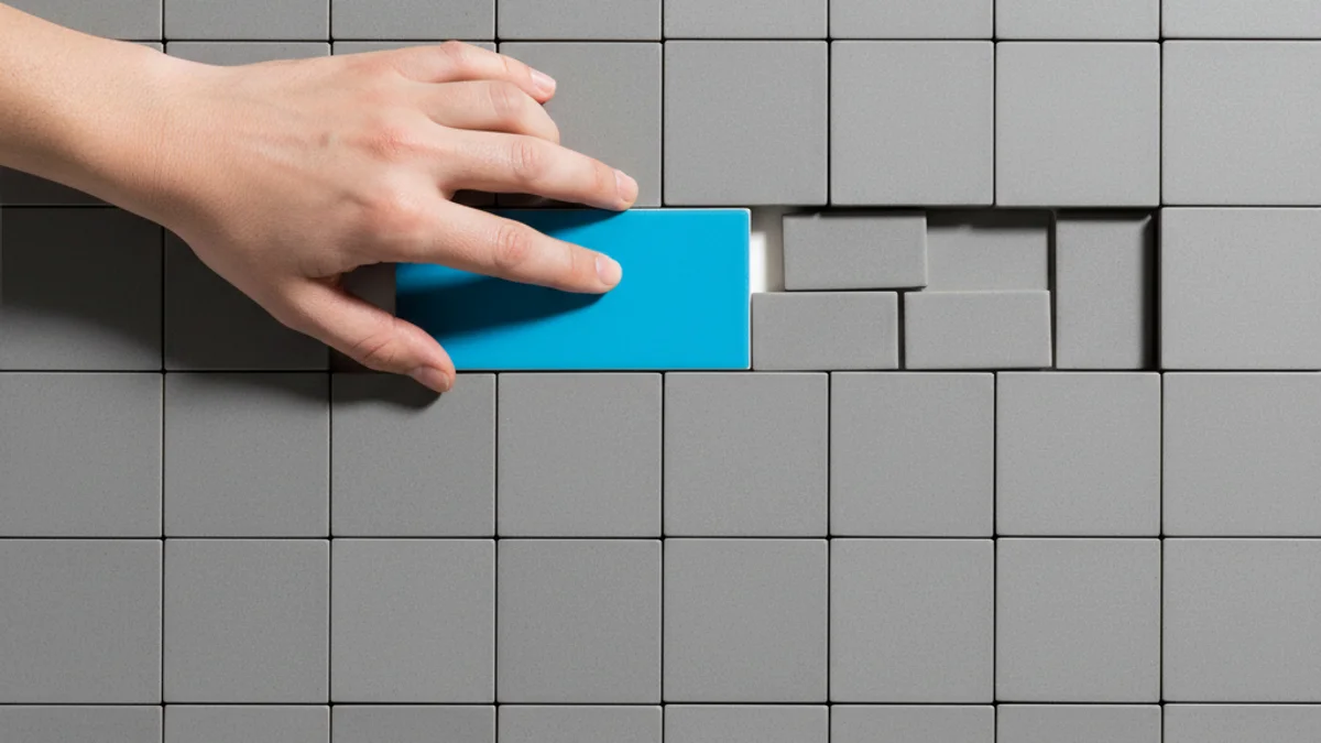 Mão deslizando azulejo azul sobre grade cinza, simbolizando mudança no marketing digital.